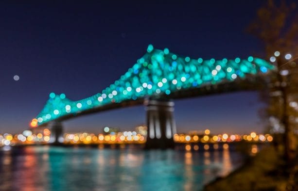 suspension bridge with teal lights during nighttime