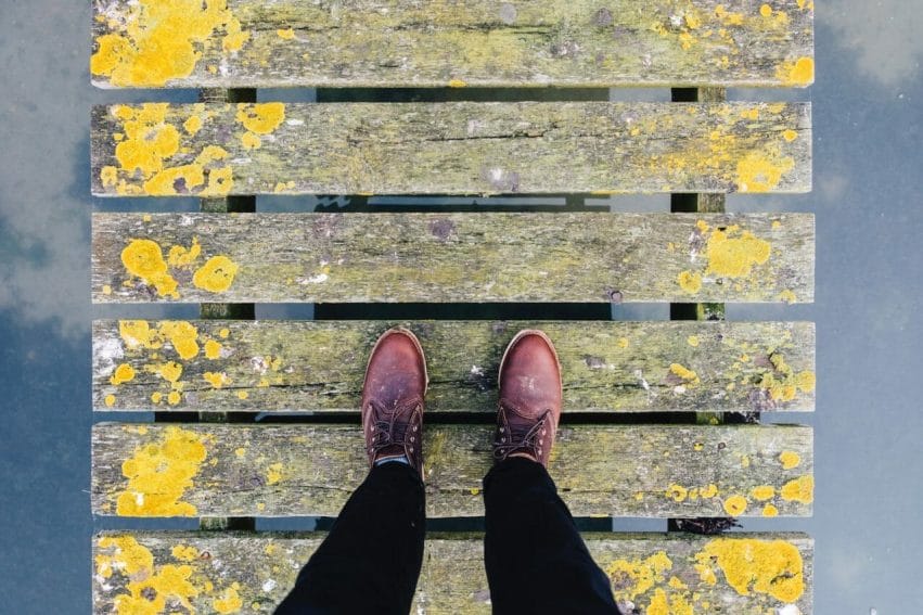 pair of brown leather shoes standing on grey and yellow bridge