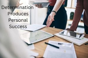 Determination Produces Personal Success with 2 people standing over a desk colobarating with working material on the desk